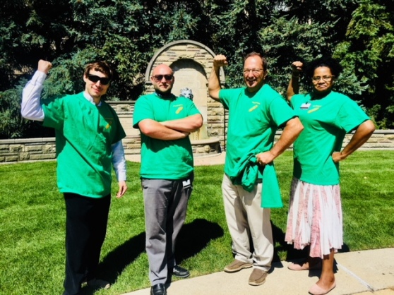 Four green-shirted "Tread Shredders" pose for a photo outside during the Going the Distance at GRCC Walking Challenge