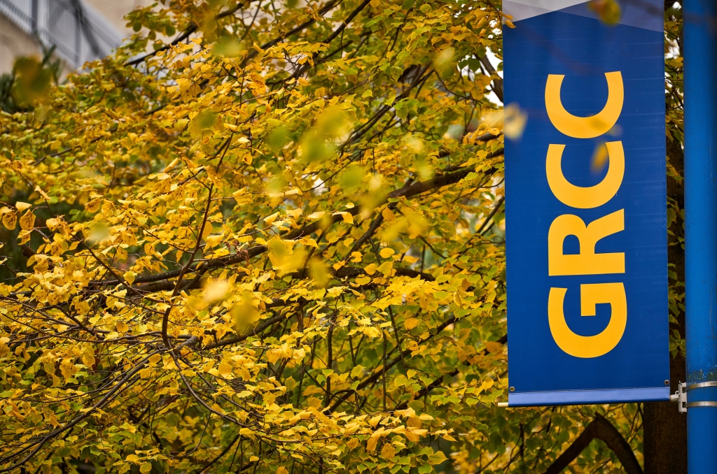 GRCC sign in front of tree with yellow fall leaves. 